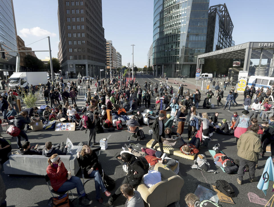 Supporters of the 'Extinction Rebellion' movement block a road at the Potsdamer Platz square in Berlin, Germany, Monday, Oct. 7, 2019. The activists want to draw attention on the climate protest by blocking roads and with other acts of civil disobedience in Berlin and other cities around the world. (AP Photo/Michael Sohn)