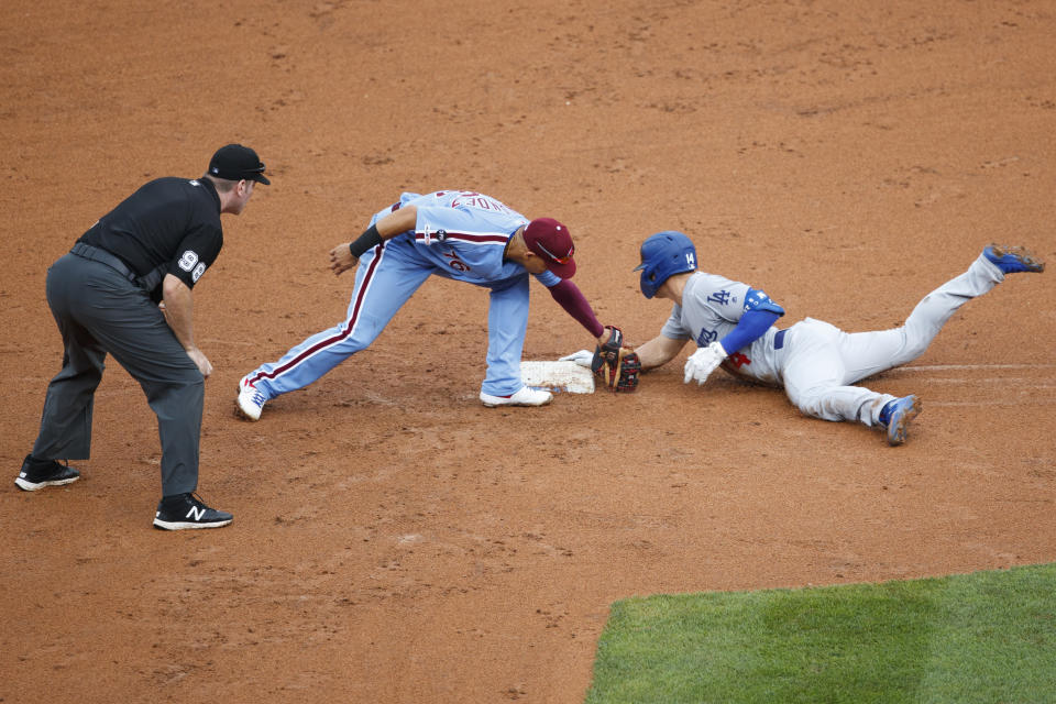 Los Angeles Dodgers' Enrique Hernandez, right, slides into second base past the tag from Philadelphia Phillies second baseman Cesar Hernandez after Hernandez hit an RBI-single during the sixth inning of a baseball game, Thursday, July 18, 2019, in Philadelphia. Hernandez advanced to second on a fielding error. (AP Photo/Matt Slocum)