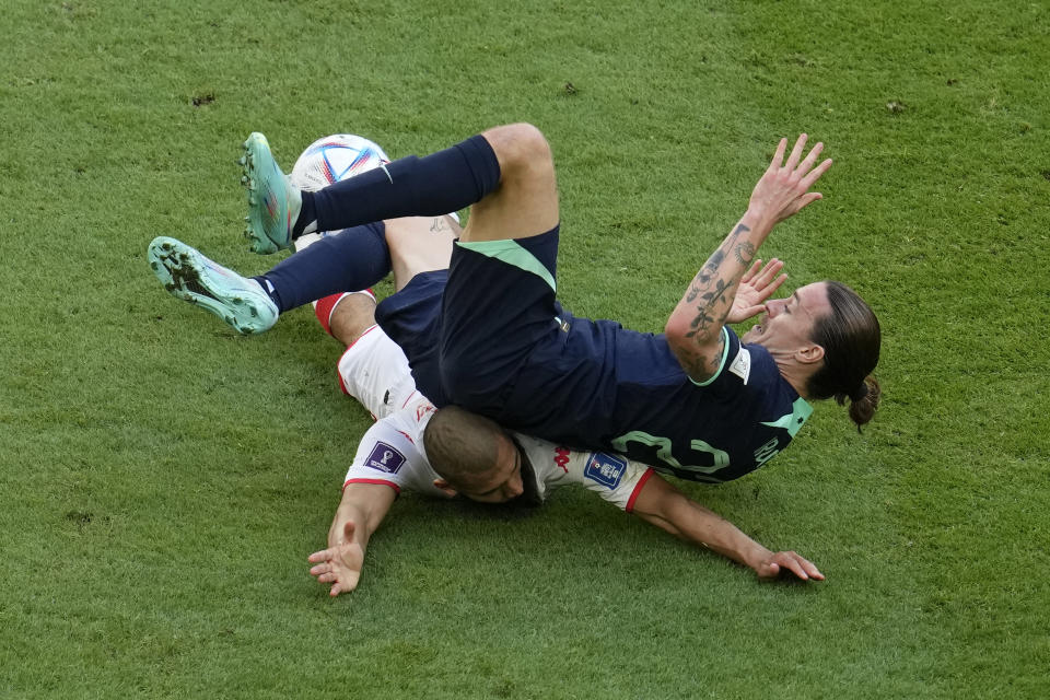 Australia's Jackson Irvine falls on Tunisia's Aissa Laidouni during the World Cup group D soccer match between Tunisia and Australia at the Al Janoub Stadium in Al Wakrah, Qatar, Saturday, Nov. 26, 2022. (AP Photo/Natacha Pisarenko)