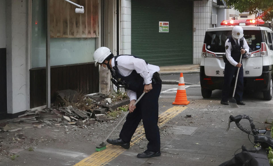 日本四國地區17日晚間發生地震，氣象廳起初判定規模6.4，後來上修為規模6.6，最大震度6弱出現在愛媛縣及高知縣。圖為愛媛縣警方在地震後協助受災戶清理。（Kyodo/路透社）