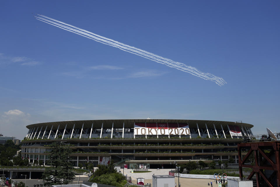 Blue Impulse of the Japan Air Self-Defense Force flies over the main National Stadium, Wednesday, July 21, 2021, in Tokyo. The National Stadium will host host the many of the events for the Tokyo 2020 Olympics that start July 23. (AP Photo/Eugene Hoshiko)