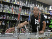 Jay Work talks to a reporter as he places tobacco on the counter next to three authentic Roor water pipes, at his Grateful J's smoke shop Thursday, Jan. 12, 2017, in Margate, Fla. High-end German glass water pipe maker Roor and its American licensee are filing lawsuits against smoke shops and mom-and-pop convenience stores in Florida, California and New York alleging that they are selling Roor counterfeits, violating its trademark. (AP Photo/Alan Diaz)