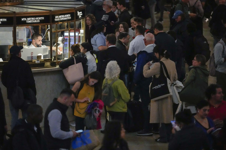 An MTA employee helps commuters as train service as been disrupted due to heavy rains at Grand Central Terminal information booth, Friday, Sept. 29, 2023, in New York. (AP Photo/Mary Altaffer)