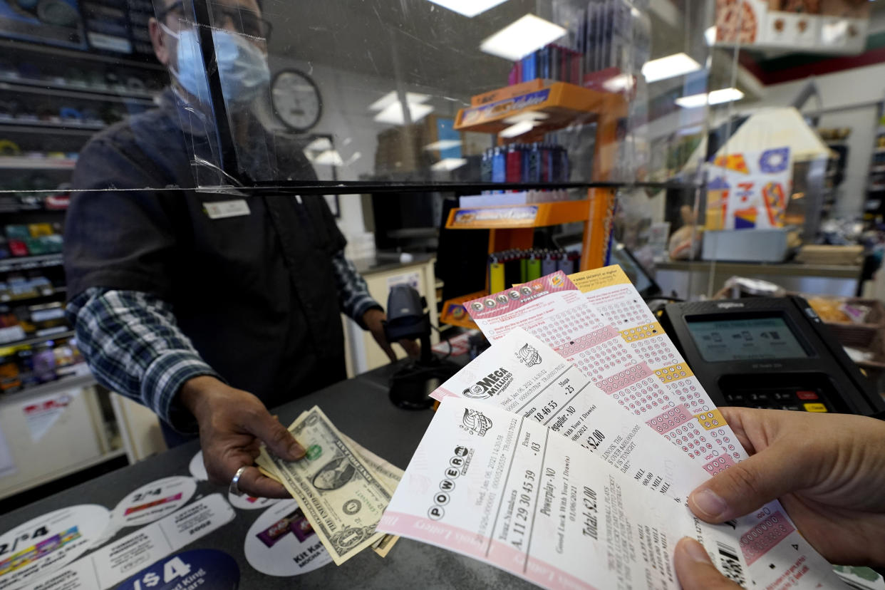 A customer purchases Powerball and Mega Millions tickets at a convenience store in Northbrook, Ill., Wednesday, Jan. 6, 2021. (AP Photo/Nam Y. Huh)