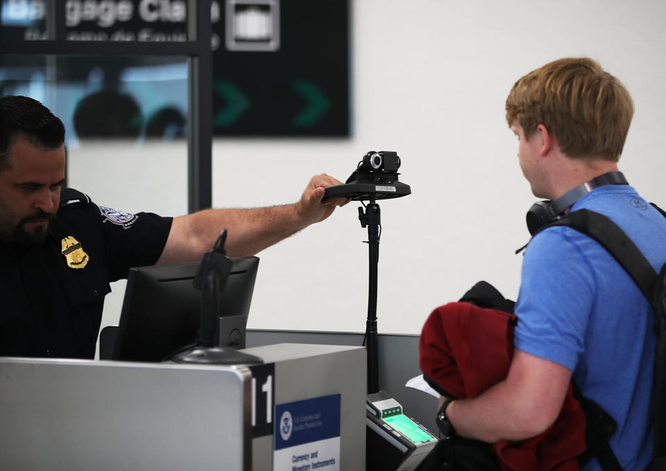 MIAMI, FL - FEBRUARY 27:  A U.S. Customs and Border Protection officer instructs an international traveler to look into a camera as he uses facial recognition technology to screen a traveler entering the United States on February 27, 2018 at Miami International Airport in Miami, Florida.  The facility is the first in the country that is dedicated to providing expedited passport screening via facial recognition technology, which verifies a traveler's identity by matching them to the document they are presenting.  (Photo by Joe Raedle/Getty Images)