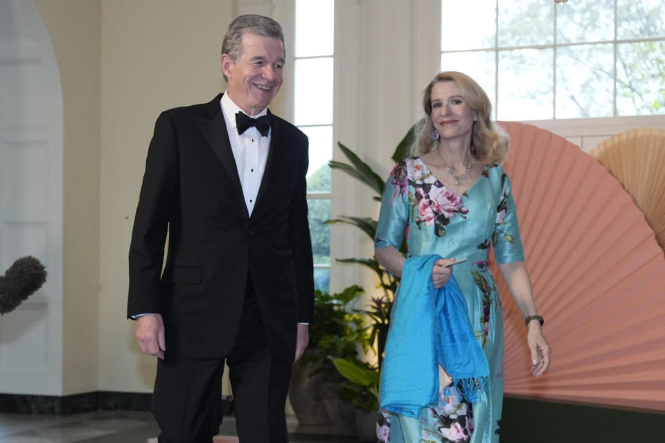 Roy Cooper, Governor of North Carolina and Kristin Cooper, arrive at the Booksellers area of the White House for the State Dinner hosted by President Joe Biden and first lady Jill Biden for Japan's Prime Minister Fumio Kishida, and wife Kishida Yuko, Wednesday, April 10, 2024, in Washington. (AP Photo/Jacquelyn Martin)