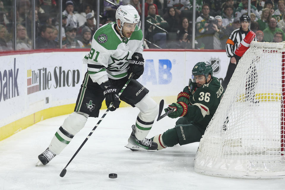 Dallas Stars center Tyler Seguin, left, skates with the puck as Minnesota Wild right wing Mats Zuccarello (36) defends during the first period of an NHL hockey game Monday, Jan. 8, 2024, in St. Paul, Minn. (AP Photo/Matt Krohn)