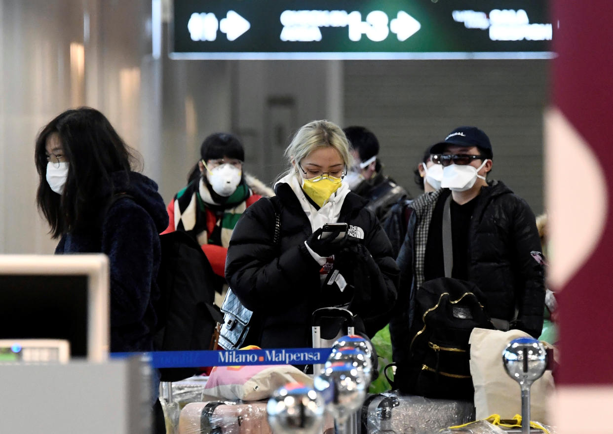 People wearing protective masks are seen at Malpensa airport near Milan, Italy, March 9, 2020. REUTERS/Flavio Lo Scalzo