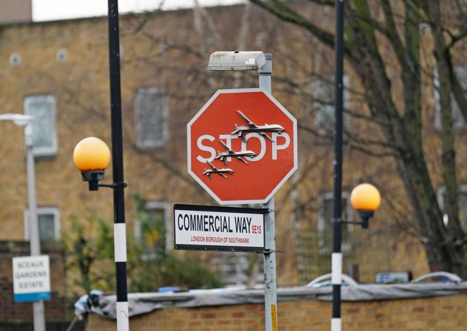 The artwork shows three drones perched on a stop sign (PA)