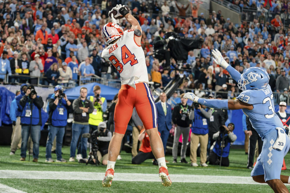 Clemson tight end Davis Allen (84) catches the ball for a touchdown while covered by North Carolina linebacker Cedric Gray (33) in the first half during the Atlantic Coast Conference championship NCAA college football game on Saturday, Dec. 3, 2022, in Charlotte, N.C. (AP Photo/Jacob Kupferman)