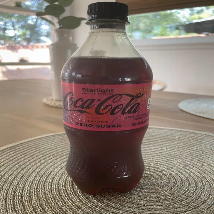 A bottle of Coke Starlight sitting on a table