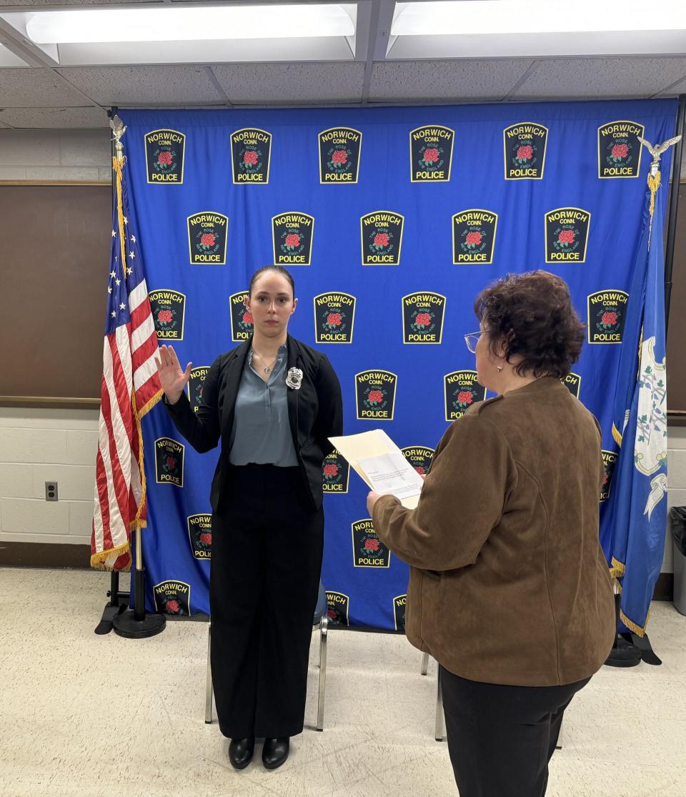 Norwich City Clerk Roseanne Muscarella reads the oath of office to police officer recruit Alexis Freel.