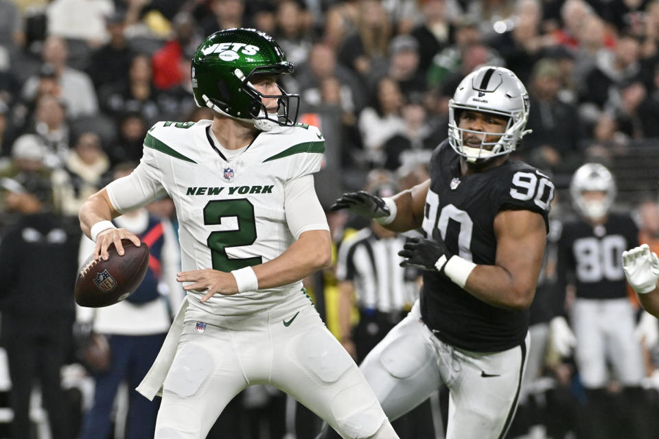 New York Jets quarterback Zach Wilson (2) throws under pressure from Las Vegas Raiders defensive tackle Jerry Tillery (90) during the first half of an NFL football game Sunday, Nov. 12, 2023, in Las Vegas. (AP Photo/David Becker)