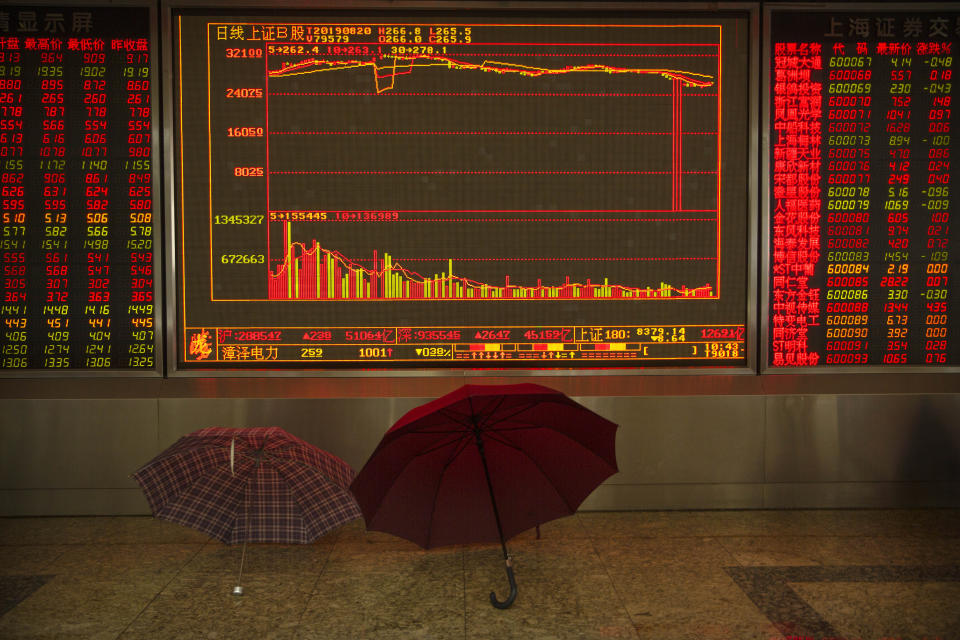 Umbrellas sit in front of an electronic display board at a stock brokerage house in Beijing, Tuesday, Aug. 20, 2019. Asian shares were mostly higher Tuesday after Wall Street rallied on the U.S. decision to give Chinese telecom giant Huawei another 90 days to buy equipment from American suppliers. (AP Photo/Mark Schiefelbein)