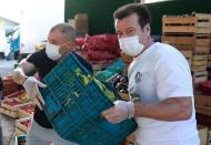 Former Brazil's head soccer coach Dunga and Internacional's soccer club player Andres D'Alessandro help with food distribution to poor people, amid the coronavirus disease (COVID-19) outbreak, in Porto Alegre