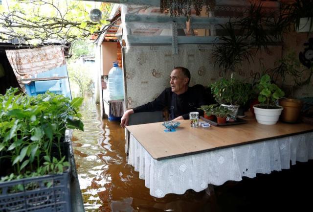 Medunov sits in his summer kitchen on a flooded island which locals and officials say is caused by Russia's chaotic control of the Kakhovka dam downstream, near Zaporizhzhia