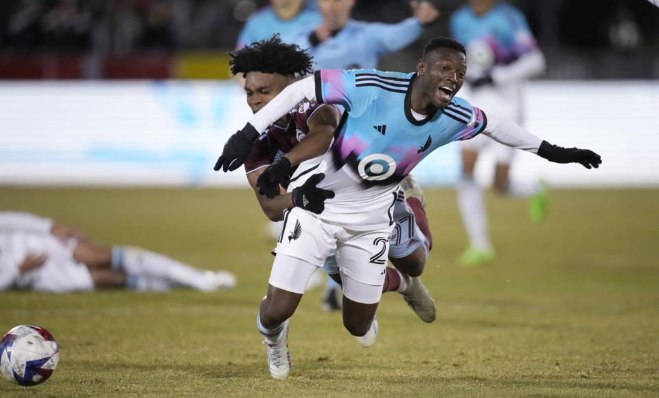 Minnesota United forward Bongokuhle Hlongwane, front, falls as he is hit by Colorado Rapids midfielder Ralph Priso during the second half of an MLS soccer match Saturday, March 18, 2023, in Commerce City, Colo. (AP Photo/David Zalubowski)