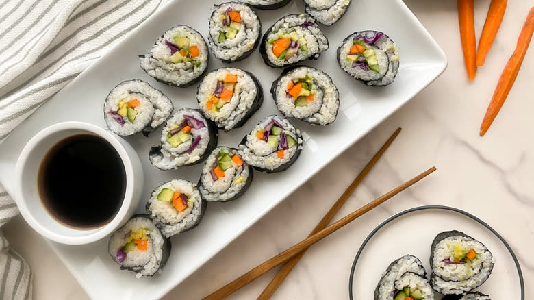 Top-down view of plated sushi rolls and soy sauce