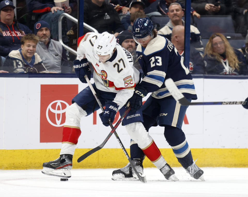 Florida Panthers forward Eetu Luostarinen, left, works for the puck in front of Columbus Blue Jackets defenseman Jake Christiansen during the second period an NHL hockey game in Columbus, Ohio, Sunday, Nov. 20, 2022. (AP Photo/Paul Vernon)