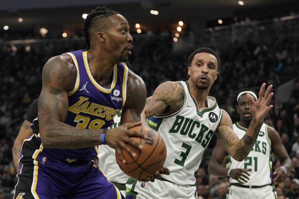 Los Angeles Lakers' Dwight Howard is fouled as he tries to shoot past Milwaukee Bucks' George Hill during the first half of an NBA basketball game Wednesday, Nov. 17, 2021, in Milwaukee. (AP Photo/Morry Gash)