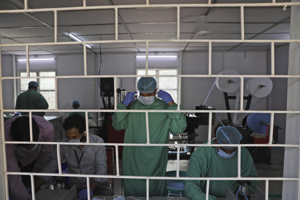 Central Reserve Police Force soldiers stitch face masks for health workers combating the spread of the new coronavirus in New Delhi, India, Friday, April 10, 2020. The new coronavirus causes mild or moderate symptoms for most people, but for some, especially older adults and people with existing health problems, it can cause more severe illness or death. (AP Photo/Manish Swarup)