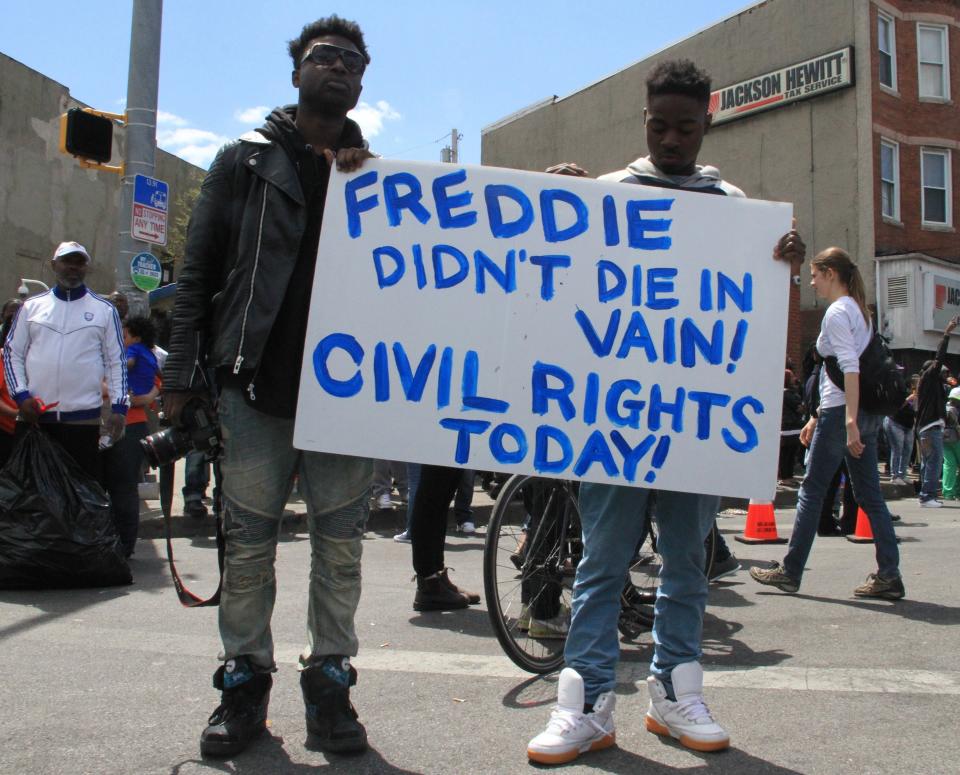 BALTIMORE, MD - APRIL 28: People protest near the CVS pharmacy that was set on fire yesterday during rioting after the funeral of Freddie Gray, on April 28, 2015 in Baltimore, Maryland. Protests following the death of Freddie Gray from injuries suffered while in police custody have turned violent with people throwing debris at police and media and burning cars and businesses. (Photo by Muhammed Bilal Kenasari/Anadolu Agency/Getty Images)