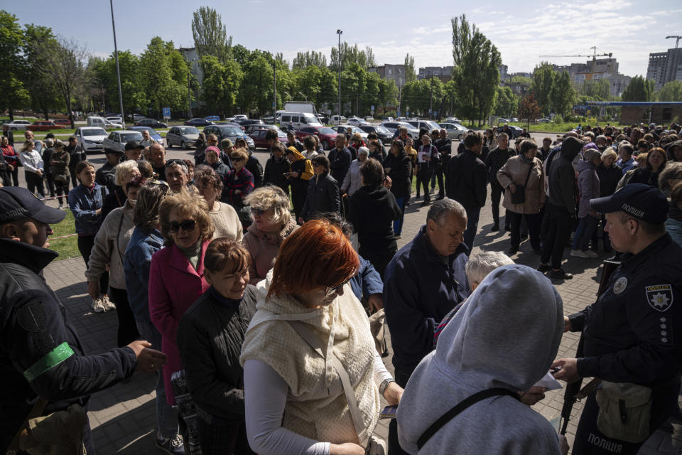 People stand in line for registration at the aid distribution center for displaced people in Zaporizhia, Ukraine, Thursday, May 5, 2022. (AP Photo/Evgeniy Maloletka)
