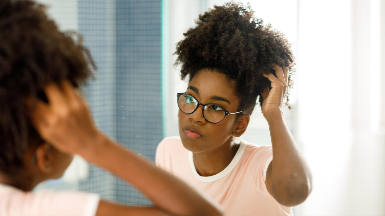  Girl looking at herself in the mirror. 