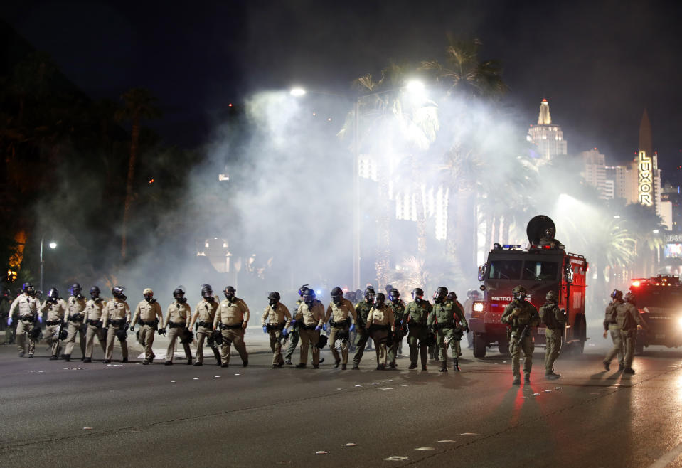 Las Vegas police disperse protesters with gas on the Las Vegas Strip on Sunday, May 31, 2020, in Las Vegas, during demonstrations over the death of George Floyd, who died May 25 after he was pinned at the neck by a Minneapolis police officer.  (AP Photo/Steve Marcus)