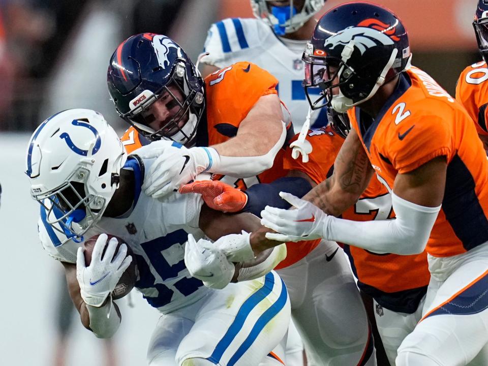 Deon Jackson fights through a tackle against the Denver Broncos.