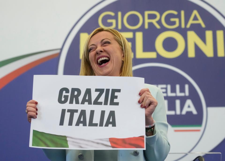 Giorgia Meloni shows a placard reading in Italian "Thank you Italy" at her party's electoral headquarters in Rome, on Sept. 26, 2022.