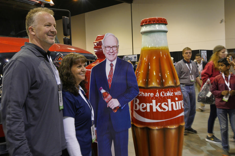 Berkshire Hathaway shareholders pose with a cutout of Chairman and CEO Warren Buffett, at the Coca Cola booth, Friday, May 3, 2019, during a shareholder shopping day, one day before Berkshire Hathaway's annual shareholders meeting. An estimated 40,000 people are expected in town for the event, where Buffett and Munger preside over the meeting and spend hours answering questions. (AP Photo/Nati Harnik)