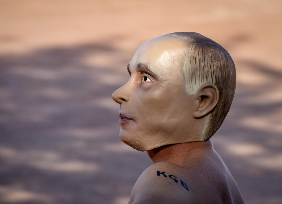 A man wearing a Vladimir Putin mask takes part in a demonstration for prisoned Alexei Navalny in Geneva, Switzerland Tuesday, June 15, 2021. US President Joe Biden and Russia President Vladimir Putin will meet for talks in Geneva on Wednesday. (AP Photo/Michael Probst)