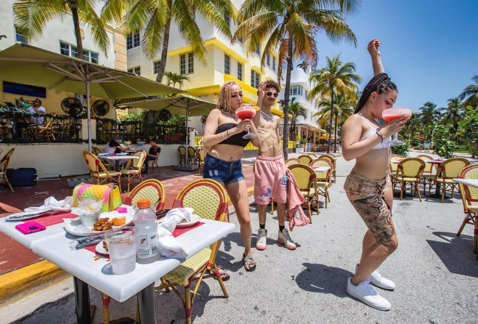 McKenzie Moore, 21, Bryce Salter, 18, and Cataleya Mordanado, 22, left to right, dance on Ocean Drive during lunch as Il Giardino expands onto a portion of the closed South Beach roadway on Wednesday.