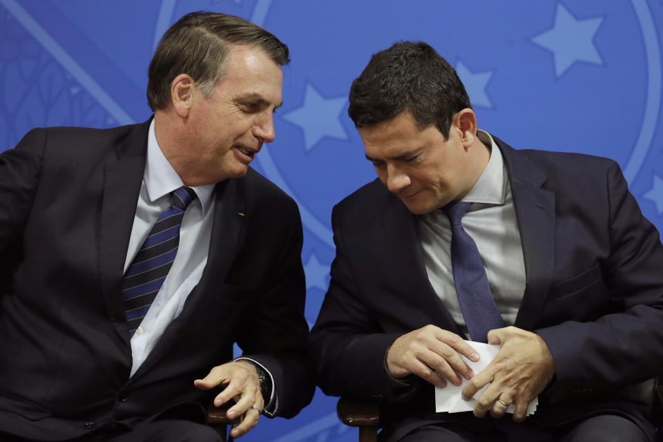 FILE - Brazil's President Jair Bolsonaro speaks to his Justice Minister Sergio Moro during a ceremony at the Planalto presidential palace in Brasilia, Monday, June 17, 2019. Their alliance didn’t last long. Moro quit the government in 2020 before he managed to implement his anti-corruption agenda, alleging Bolsonaro was interfering in the federal police force. (AP Photo/Eraldo Peres, File)