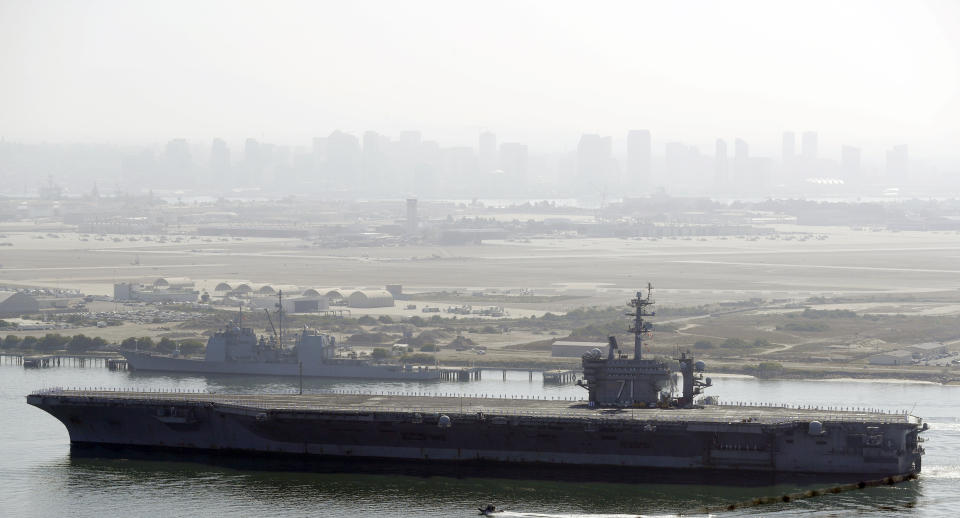 FILE - In this July 9, 2020 file photo the USS Theodore Roosevelt aircraft carrier makes its way into San Diego Bay as seen from San Diego. Capt. Brett Crozier the dismissed captain of the U.S. Navy aircraft carrier knew he was jeopardizing his military career when he broke protocol and sent a now-famous email warning of possible sailor deaths due to a coronavirus breakout on board, but he did so in an urgent effort to help avoid a "larger catastrophe," he wrote in a witness statement obtained by the San Francisco Chronicle. (AP Photo/Gregory Bull, File)