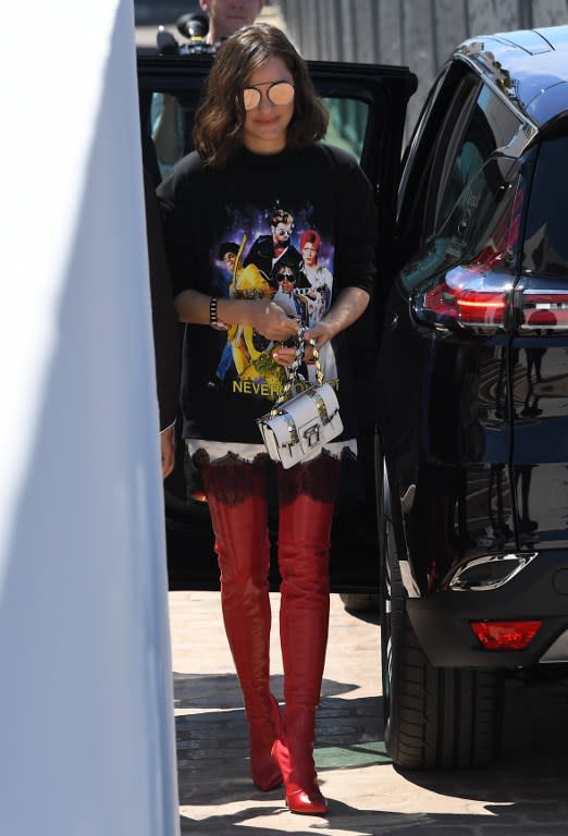 <p>On n’avait sans doute jamais vu Marion Cotillard dans une telle tenue : des cuissardes rouges et un tee-shirt ample rempli de popstars. (crédit AFP) </p>