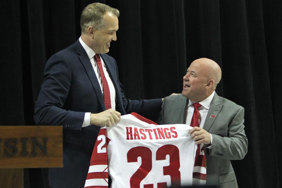 Wisconsin athletic director Chris McIntosh, left, presents men's hockey coach Mike Hastings with a Badger jersey during Hastings' introductory news conference Monday at the Kohl Center.