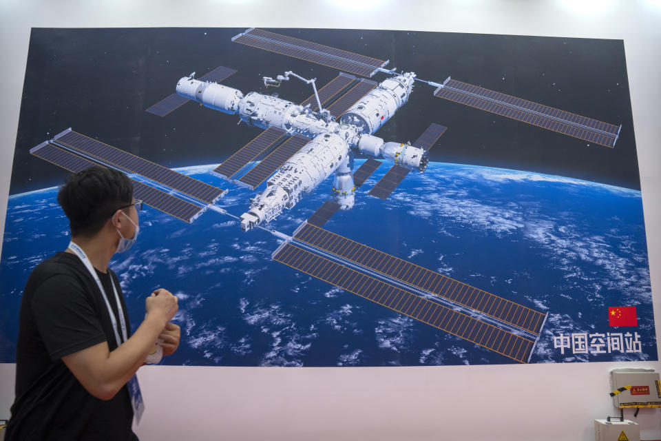 A visitor looks at a mural showing an artist's rendering of China's space station at the World Robot Conference in Beijing, Saturday, Sept. 11, 2021. Three Chinese astronauts have departed from the country’s orbiting space station in preparation for returning to Earth after 90 days in orbit, the national space agency reported Thursday, Sept. 16, 2021. (AP Photo/Mark Schiefelbein)