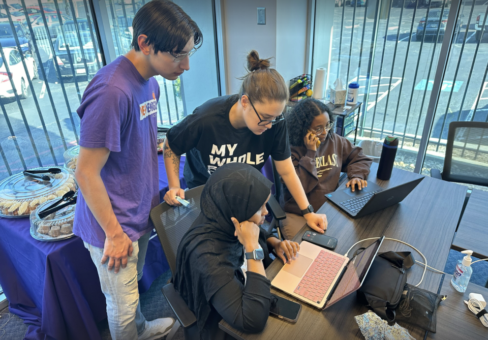  Miko Dougherty, center top, examines the registration status of a voter that requested a ride to the polls during last month’s Georgia primary. (Matt Vasilogambros/Stateline)