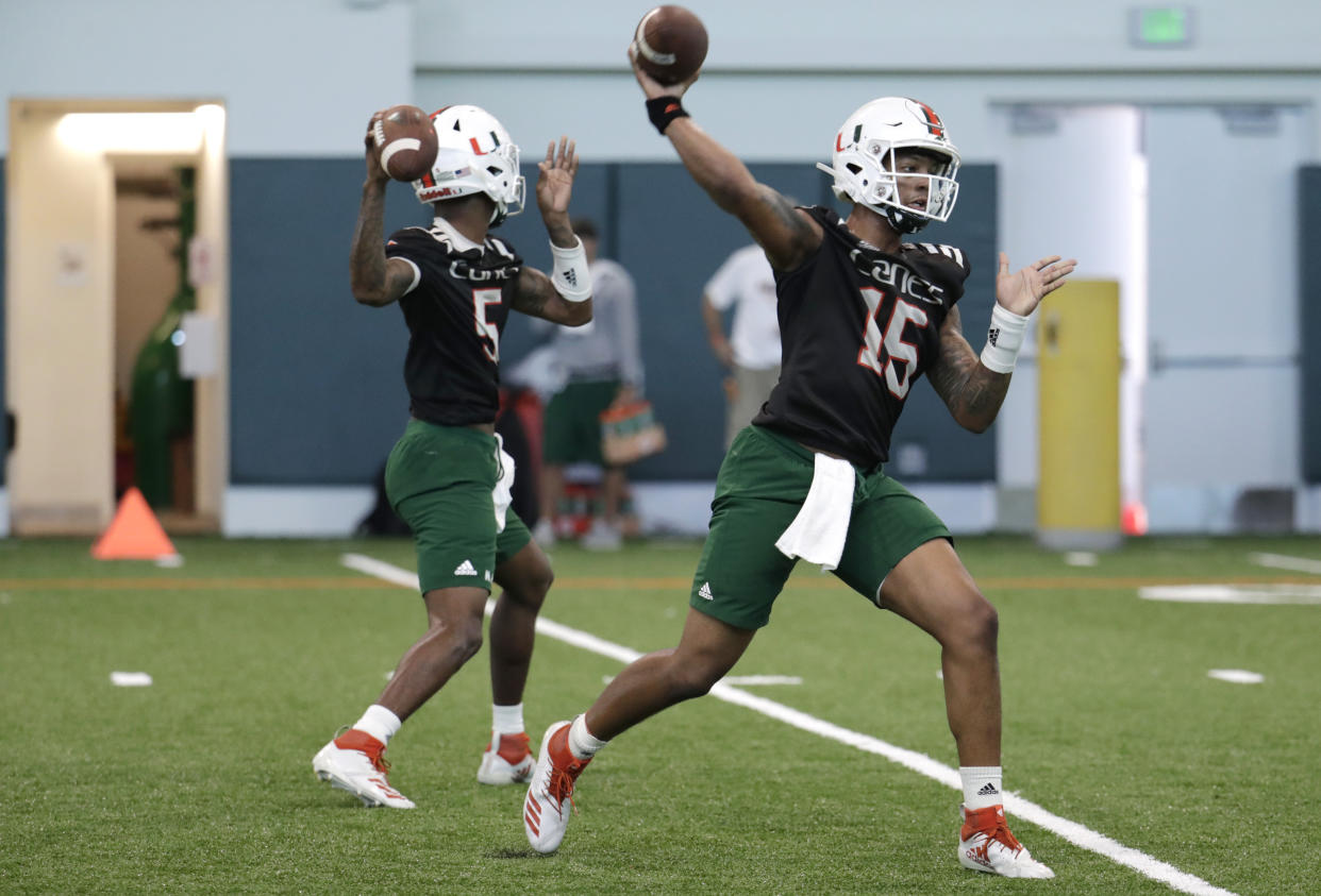 Miami quarterbacks N'Kosi Perry (5) and Jarren Williams (15) do drills during NCAA college football spring practice, Thursday, April 18, 2019, in Coral Gables, Fla. (AP Photo/Lynne Sladky)