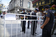 Security guards put up barriers for access control at a tourist shopping street in Beijing, Tuesday, Aug. 3, 2021. Chinese authorities announced Tuesday mass coronavirus testing in Wuhan as an unusually wide series of COVID-19 outbreaks reached the city where the disease was first detected in late 2019. The current outbreaks, while still in the hundreds of cases in total, have spread much more widely than previous ones, reaching multiple provinces and cities including the capital, Beijing. (AP Photo/Mark Schiefelbein)