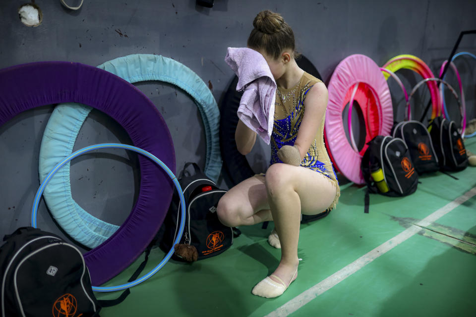 Sara Becarevic wipes her face during a training session in Visoko, Bosnia, Wednesday, Dec. 1, 2021. In Bosnia, a poor, Balkan country which habitually marginalizes people with disabilities, a soon-to-be-14-year-old girl, born without her lower left arm, pursues her dream of becoming an internationally recognized rhythmic gymnast. Sara Becarevic says she got enchanted with the demanding sport as a toddler, while watching the world championships on television. (AP Photo)