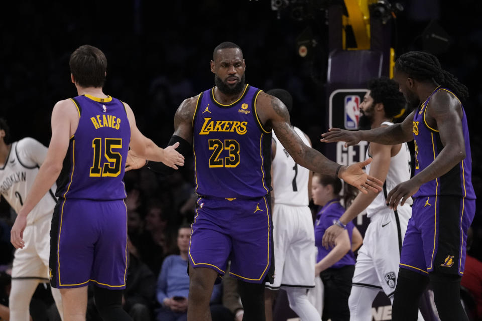 Los Angeles Lakers forward LeBron James (23) celebrates with guard Austin Reaves (15) and forward Taurean Prince (12) during the first half of an NBA basketball game in Los Angeles, Friday, Jan. 19, 2024. (AP Photo/Ashley Landis)