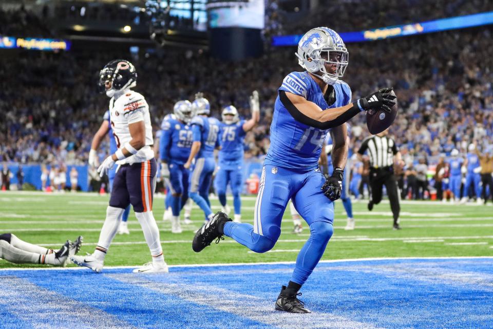Detroit Lions receiver Amon-Ra St. Brown celebrates a touchdown against the Chicago Bears at the end of the first half at Ford Field on Sunday, Nov. 19, 2023.