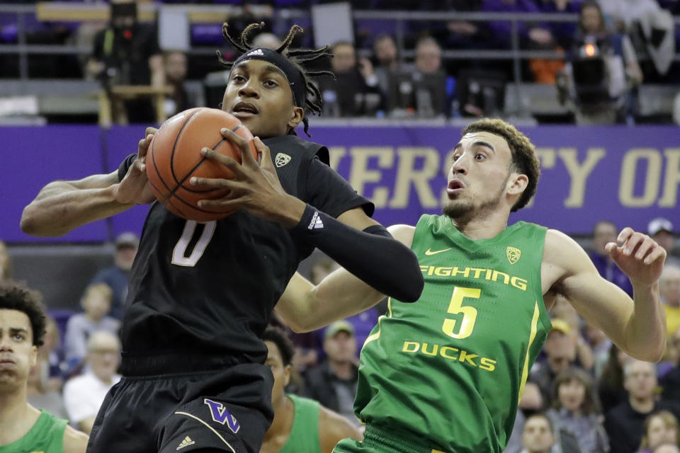 Washington forward Jaden McDaniels (0) grabs a rebound in front of Oregon guard Chris Duarte (5) during the first half of an NCAA college basketball game, Saturday, Jan. 18, 2020, in Seattle. (AP Photo/Ted S. Warren)