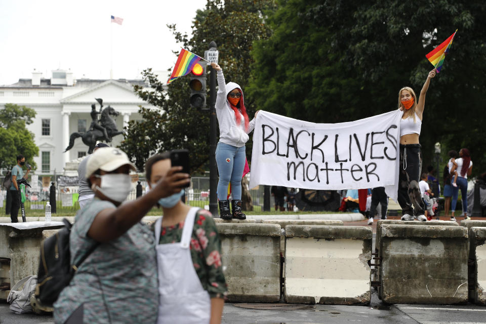 FILE - In this June 20, 2020, file photo, protesters gather on a part of 16th Street Northwest renamed Black Lives Matter Plaza near the White House in Washington. Black Lives Matter activists are holding a virtual Black National Convention Friday, Aug. 28, to adopt a political agenda calling for slavery reparations, universal basic income, environmental justice and legislation that entirely re-imagines criminal justice reforms. (AP Photo/Patrick Semansky, File)
