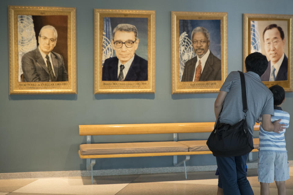 Gen Goto, left, of Tokyo, and his son Motoharu Goto, 9, pause in front of a portrait of former United Nations Secretary-General Kofi Annan during a visit to U.N. headquarters, Saturday, Aug. 18, 2018. Annan, one of the world's most celebrated diplomats and a charismatic symbol of the United Nations who rose through its ranks to become the first black African secretary-general, has died. He was 80. (AP Photo/Mary Altaffer)