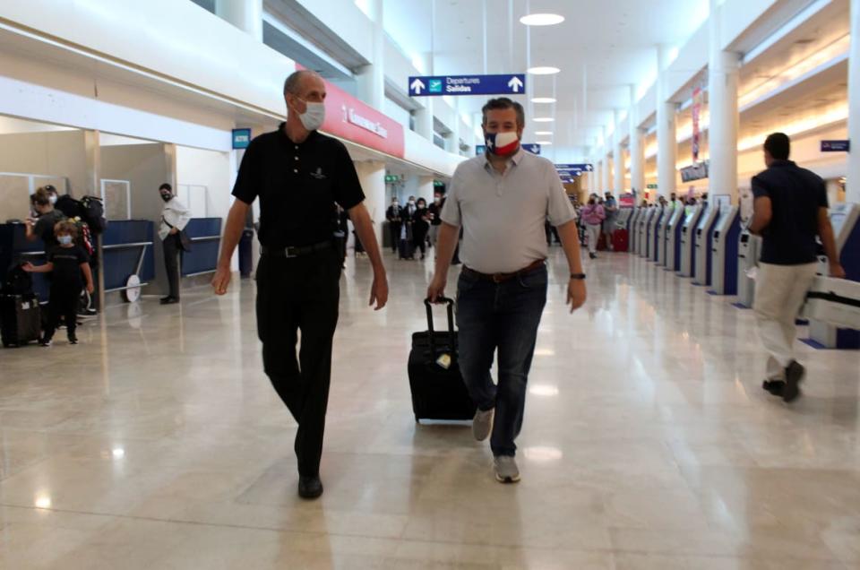 <div class="inline-image__caption"><p>Cruz walks alongside an unidentified man wearing a Ritz-Carlton t-shirt as he boards a flight back to Texas from Cancun International Airport.</p></div> <div class="inline-image__credit">Stringer/Reuters</div>