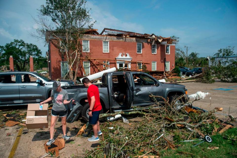 Workers salvage personal belongings from their damaged vehicles outside of Merchants and Marine Bank in Moss Point on Tuesday, June 20, 2023, after a tornado damaged the building on Monday, trapping workers inside.